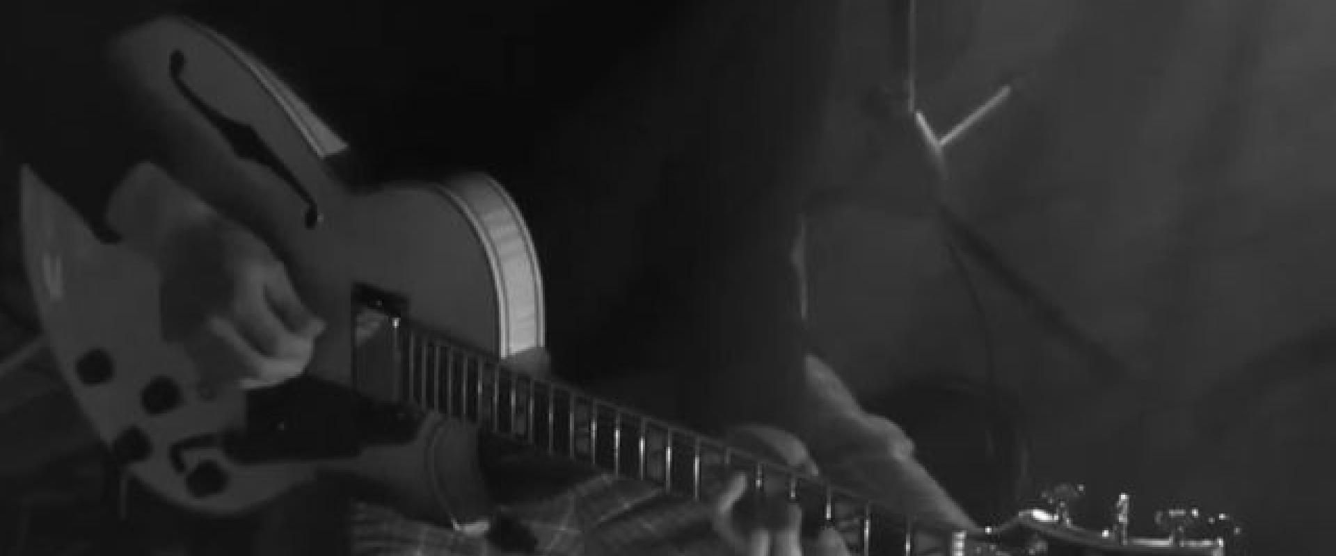 Black and white image of Gabe Mink playing guitar.